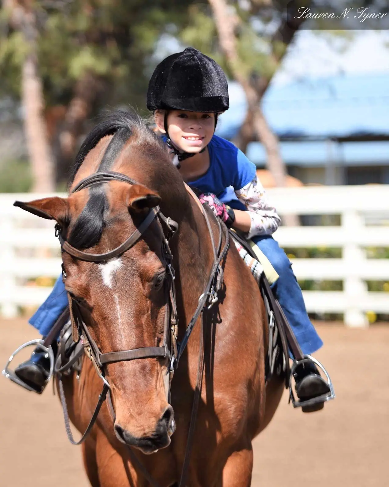A child riding with the lesson horse's head fully visible